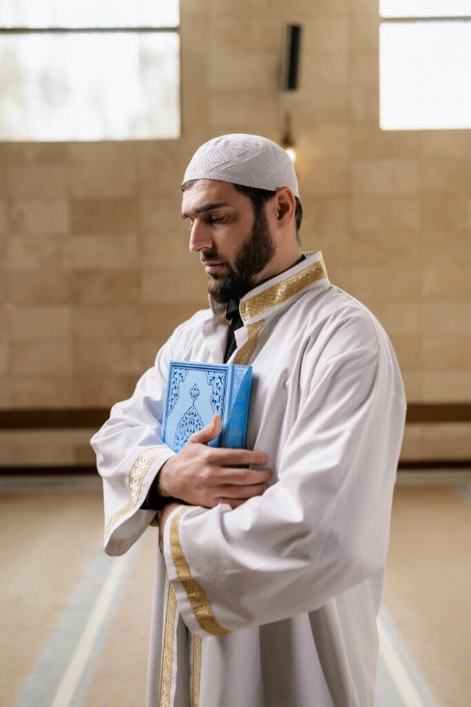 pexels-photo-8164505 A Man in White Thobe Holding a Koran with His Eyes Closed