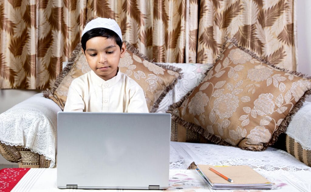 pexels-photo-4384091-4384091 Boy in traditional attire learning online at home using a laptop on the couch.